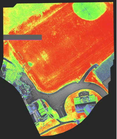 Multispectral orthomosaic of the Concord Academy wetlands: dense vegetation in red and green, pavement and water in grey.