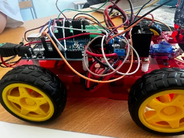 Autonomous car built by Hope School students: an Arduino board, sensors and motor drivers wired onto a red chassis with yellow wheels.