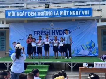 Students receiving Fresh Hydro scholarship certificates on stage at Vinh Hoa Elementary in Ben Tre.